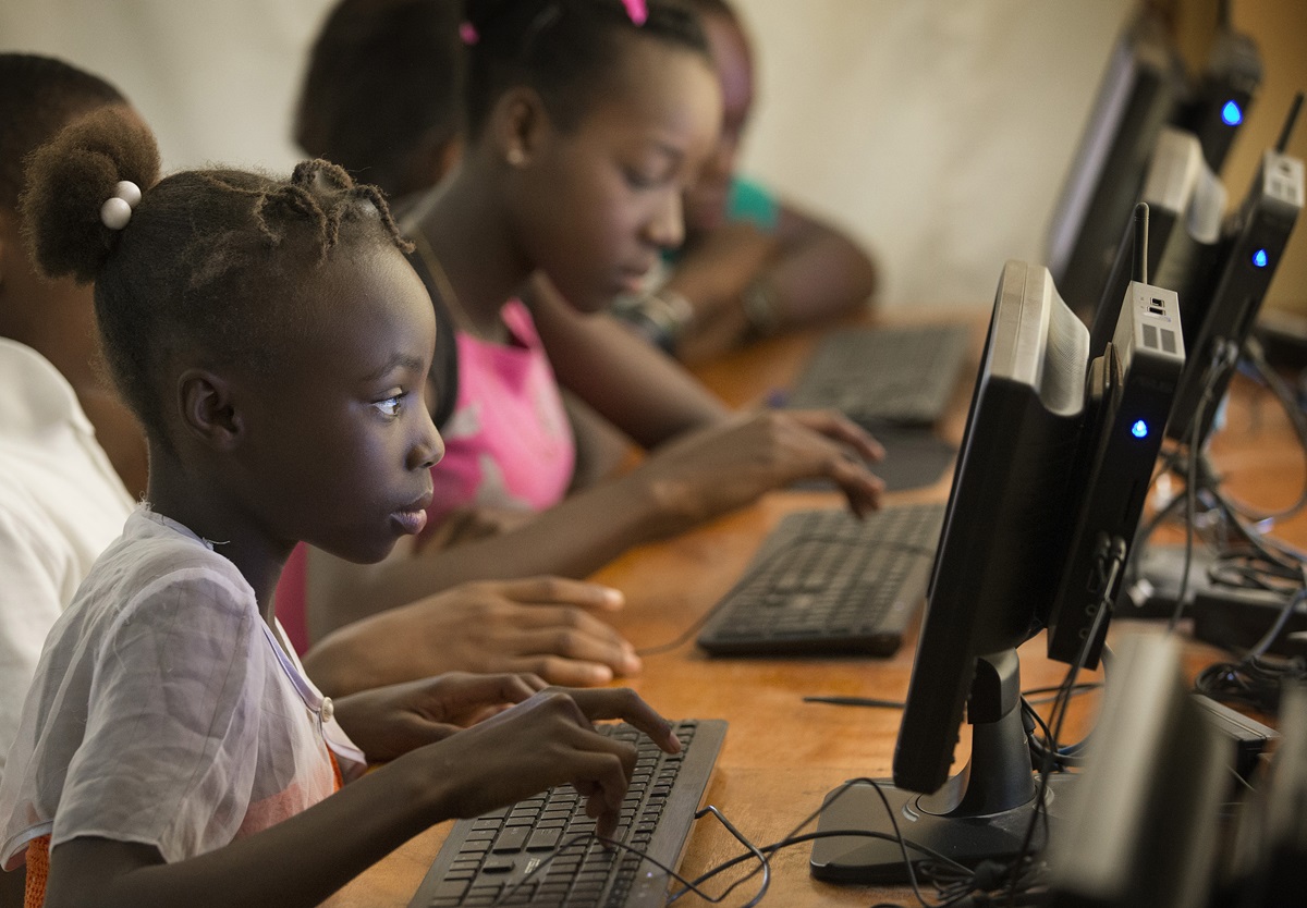 Angeline, 12, works in the computer lab at the Thomas Food Project in Thomas, Haiti. She says she wants to use the computer to write and do research.