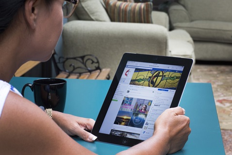 The Facebook page for the United Methodist Church is read via tablet. Photo illustration by Kathleen Barry, United Methodist Communications.