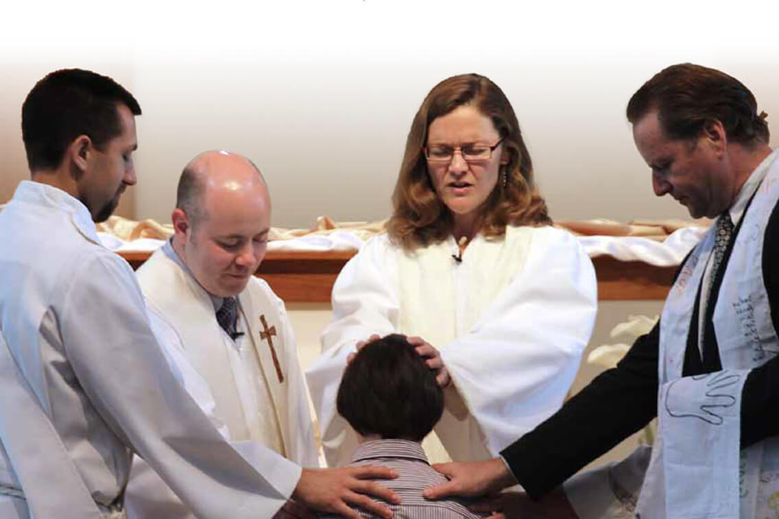 The Rev. Carol Cavin-Dillon (center) prays  for a sixth grader who has just confirmed his  faith at Christ United Methodist Church in  Franklin, Tenn. Photo by Kathleen Barry/UMNS.