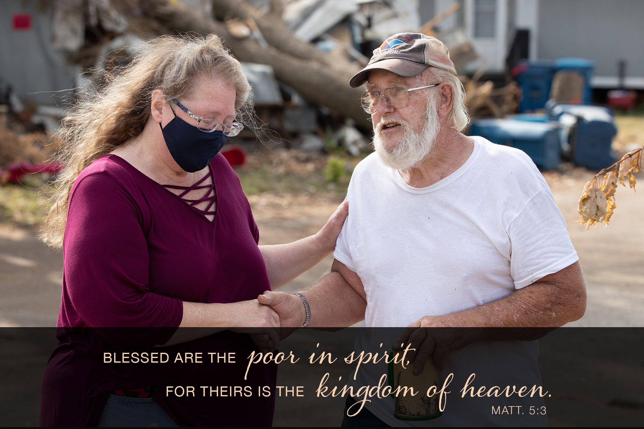 The Rev. Catie Newman prays with John Wm. Weaver in front of a neighbor's wind-damaged home while a United Methodist volunteer team makes emergency repairs to his roof in Marion, Iowa. Weaver's mobile home was severely damaged during a derecho windstorm in August. Newman is the disaster response coordinator for the Iowa Conference. Photo by Mike DuBose, UM News.