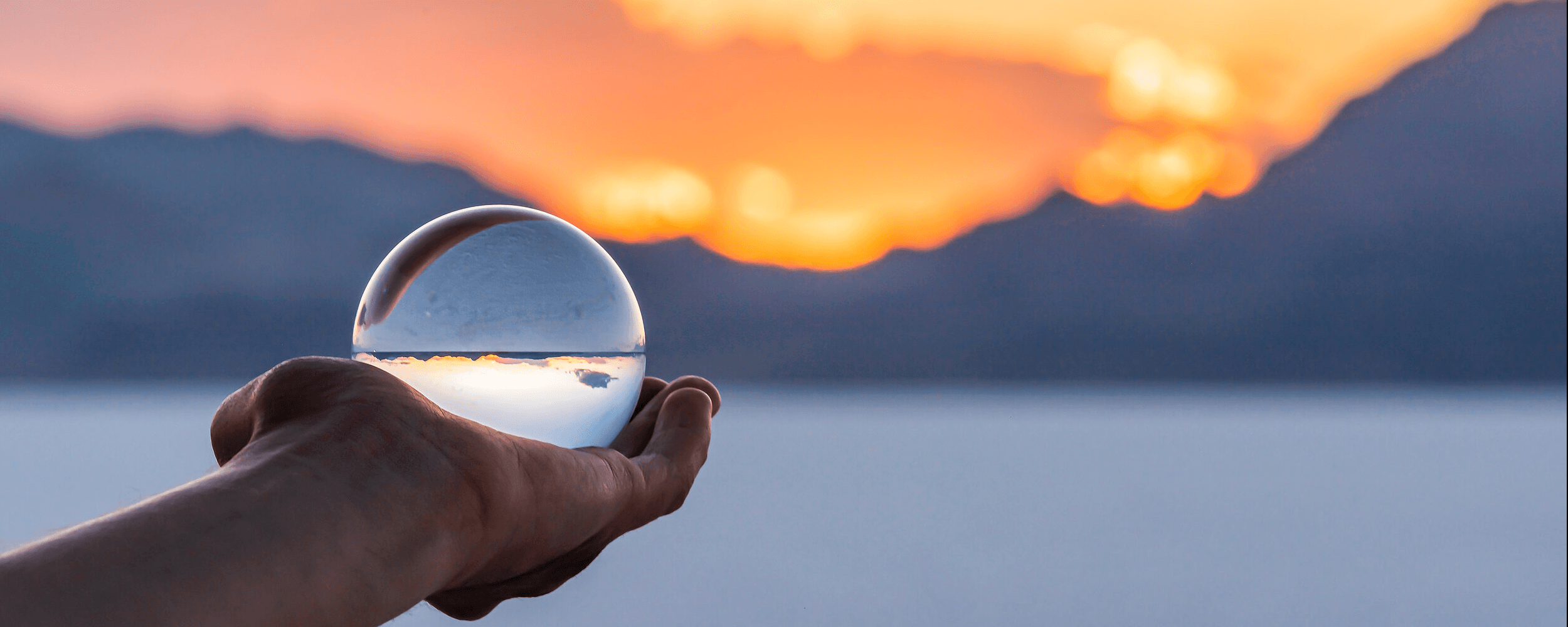 Hand holding a crystal globe with sunset in background. Image by krblokhin, iStockPhoto.com. Image courtesy of the Connectional Table. 