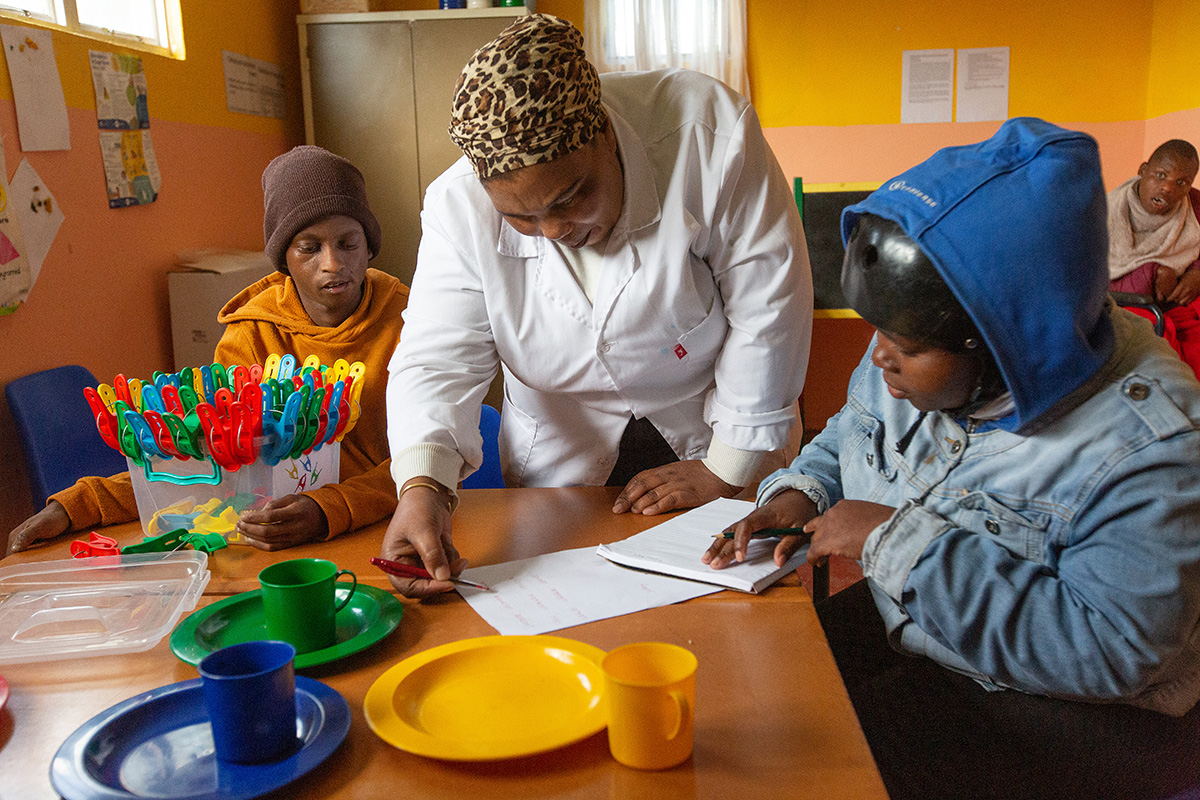 Teacher Thembakazi Bojana works with students at the Nomaxabiso Centre for Children in the Philippi East neighborhood of Cape Town, South Africa. The center, which receives support from The United Methodist Church, serves children with special educational needs. Photo by Mike DuBose, UM News.