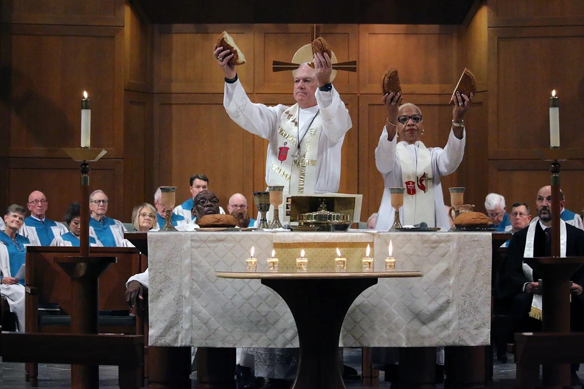 Council of Bishops President Thomas J. Bickerton and Bishop Tracy Smith Malone break bread during a Service of Remembrance and Resurrection at First United Methodist Church of Waynesville, N.C., on Nov. 6. The Council of Bishops is meeting through Nov. 11 at Lake Junaluska to discuss the future of the church and strategize for the coming General Conference. Photo by Rick Wolcott, courtesy of the Council of Bishops.