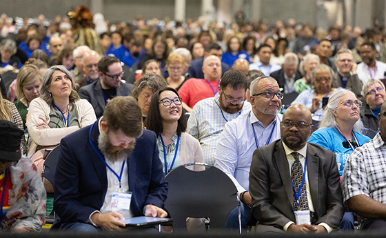 Visitors to the United Methodist General Conference in Charlotte, N.C., watch the proceedings on overhead video monitors. Photo by Mike DuBose, UM News.