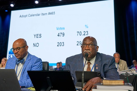 O Bispo da Conferência de West Ohio, Gregory V. Palmer (à direita) e o parlamentar Maurice S. Henderson vêm os resultados de uma votação de 3 de Maio na Conferência Geral da Metodista Unida em Charlotte, N.C. A medida eliminou as proibições de clérigos realizarem casamentos entre pessoas do mesmo sexo nas suas igrejas. As Notícias da Metodista Unida compilaram uma lista da legislação aprovada pela Conferência Geral deste ano. Foto de Paul Jeffrey, Notícias da MU.