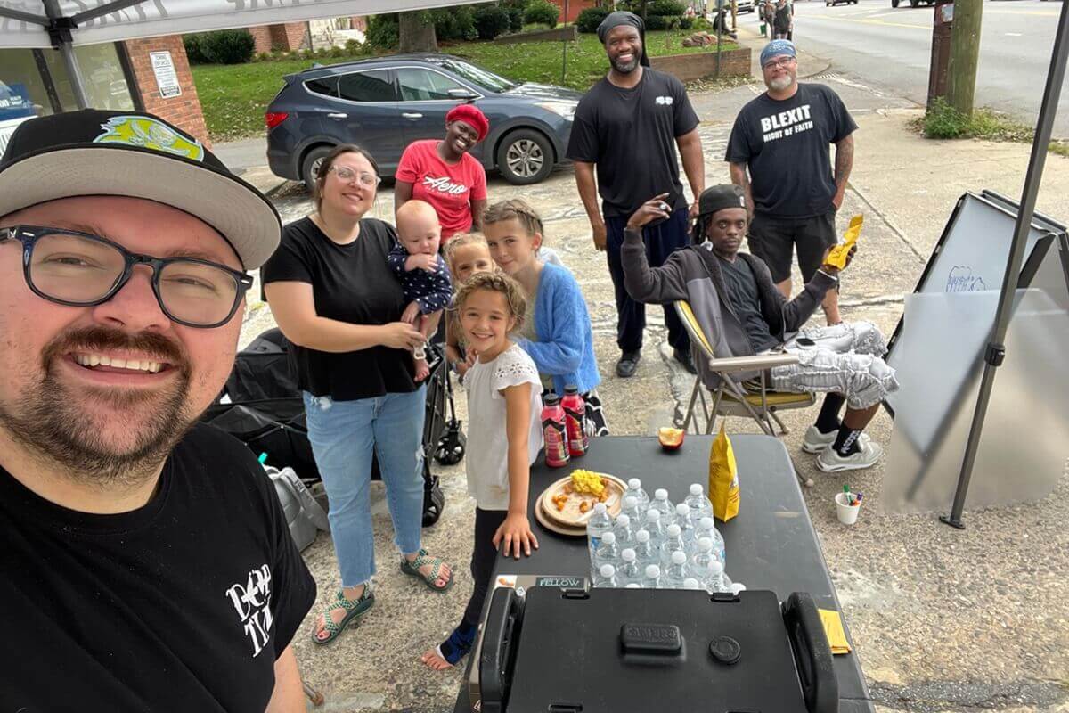 Dustin Mailman (left) and Timothy "GA" Underwood (third from right) and others from the Deep Time team host a pay-as-you-can pop-up coffee event in West Asheville following Hurricane Helene. Deep Time is a fresh expression in North Carolina. Courtesy of Luke Edwards