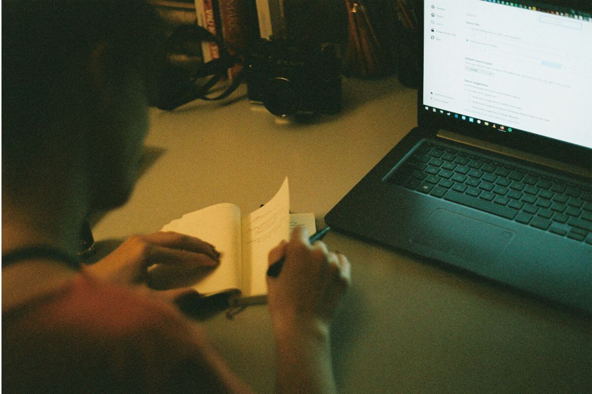 man taking notes with computer